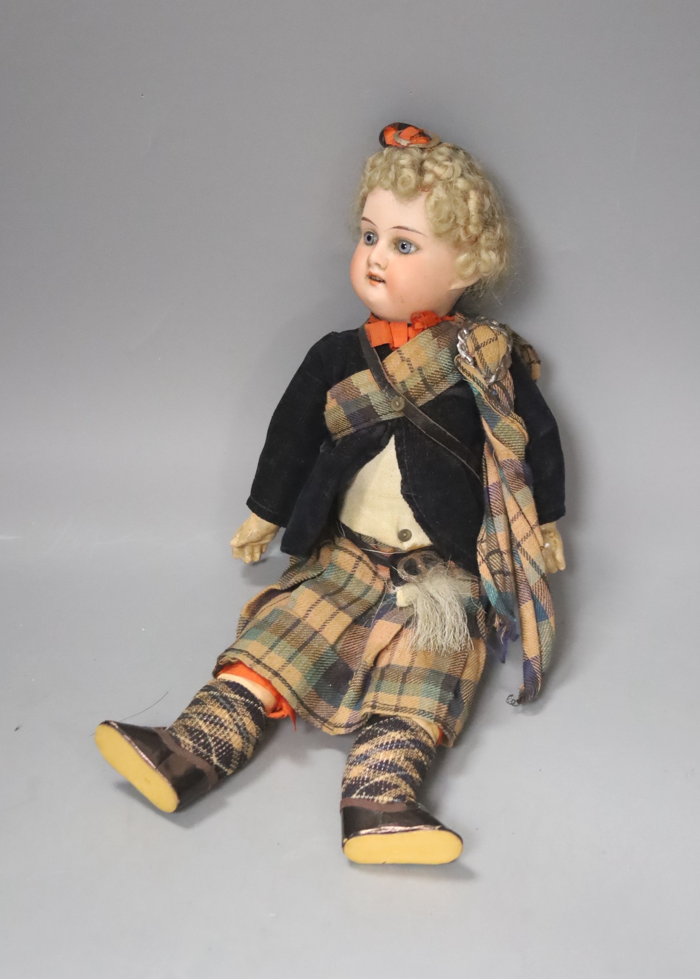 An AM bisque doll, Scottish dress. 30cm